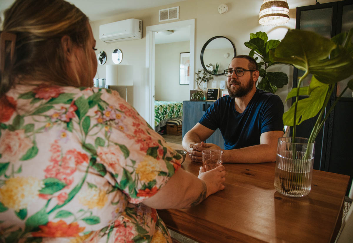 woman and man talk across table